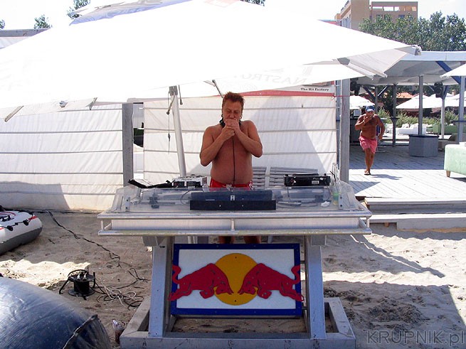 DJ gra muzykę, cała plaża jest nagłośniona. Klimat klubowy, kelnerki roznoszą ...