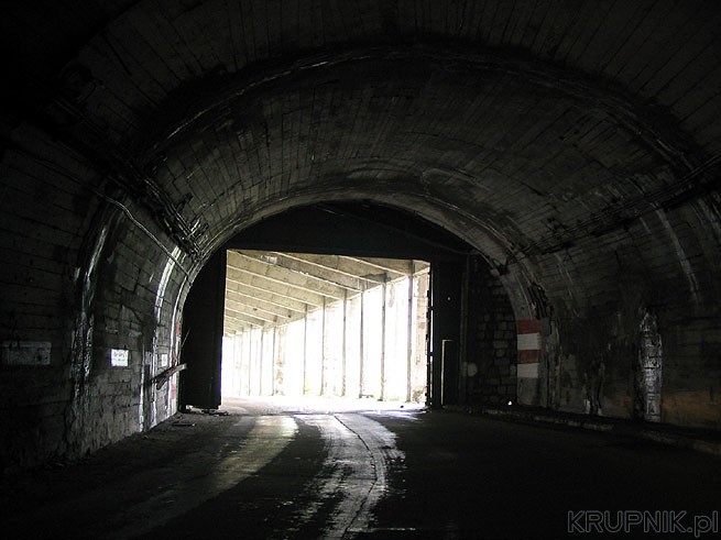Tunele są zabezpieczone stalowymi wrotami. Wyjeżdżamy pod arkady gdzie widać ...